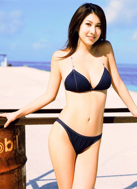 Stunning asian beauty entices in her skimpy bikini at the beach