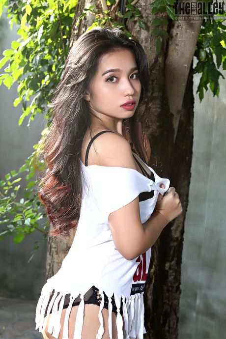 Asian teen Norah strips and shows her hairy pussy in a solo outdoors